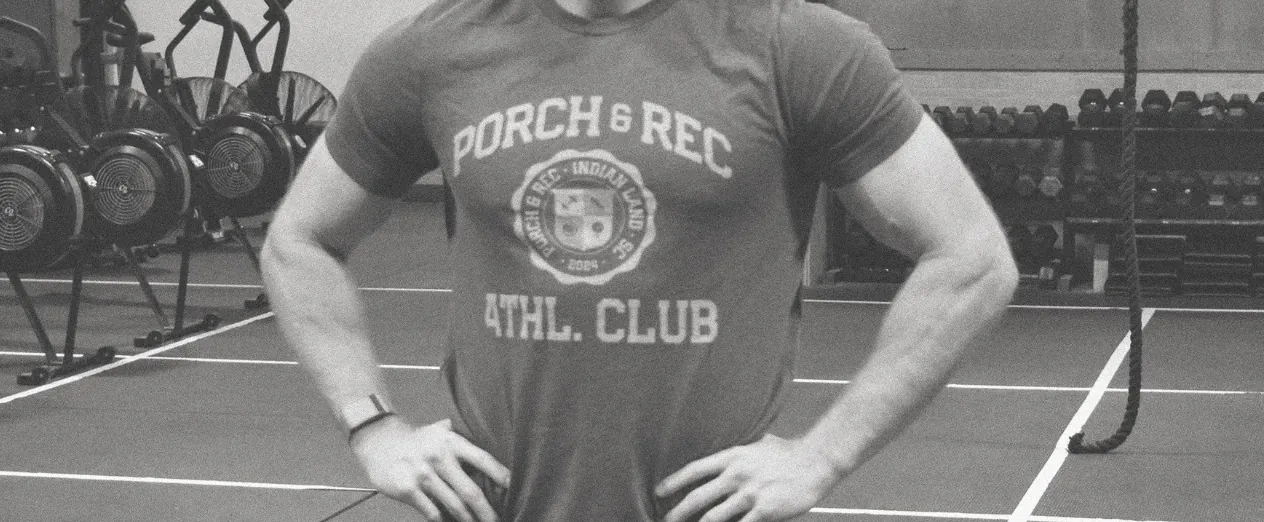 Grainy black-and-white photograph of an athlete wearing a Porch & Rec tee in the gym